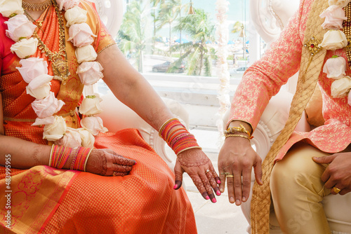 Canvas Print Indian Bride in orange dress and Groom in orange costume showing their rings Clo