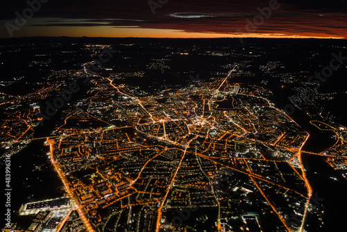 Canvastavla Aerial view from airplane window of buildings and bright illuminated streets in city residential area at night
