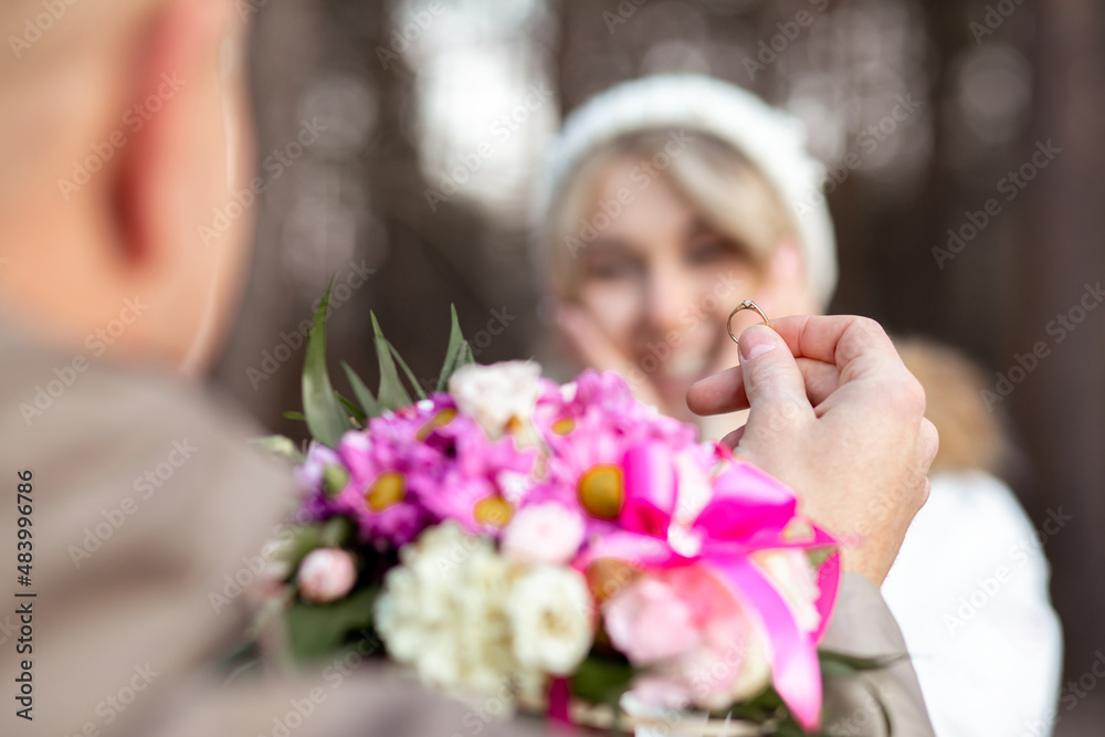 Fototapeta premium Portrait of two people couple smiling happy woman and man proposal holding bouquet of flowers together outdoors blur