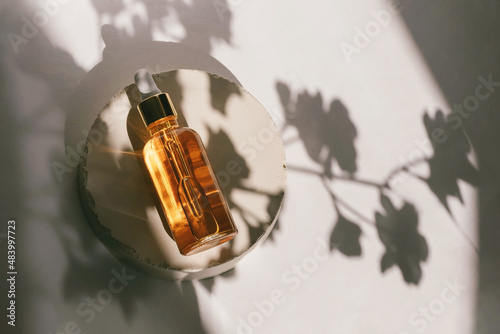Unbranded bottles in mockup style on podium with shadow top view. Tube of eye oil on a white background. Beauty background with facial cosmetic products. Spa, beauty concept.