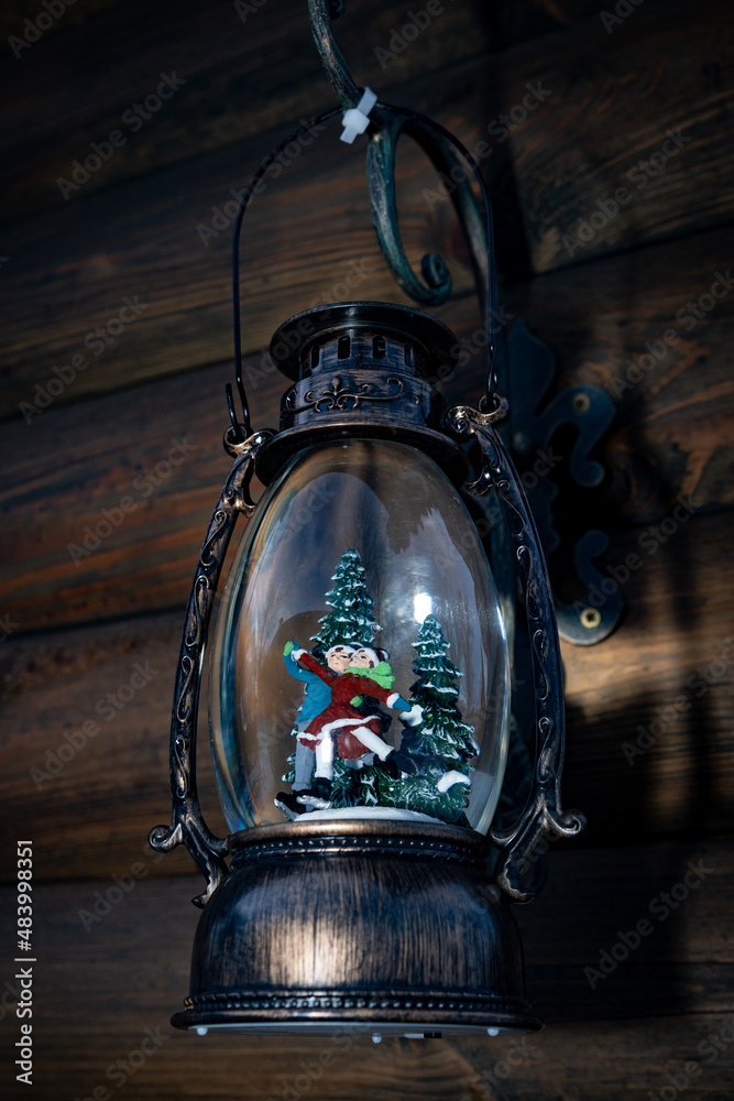 A lamp, with a pair of figure skaters, inside it. An unusual lamp decorated in the style of New Year and Christmas.