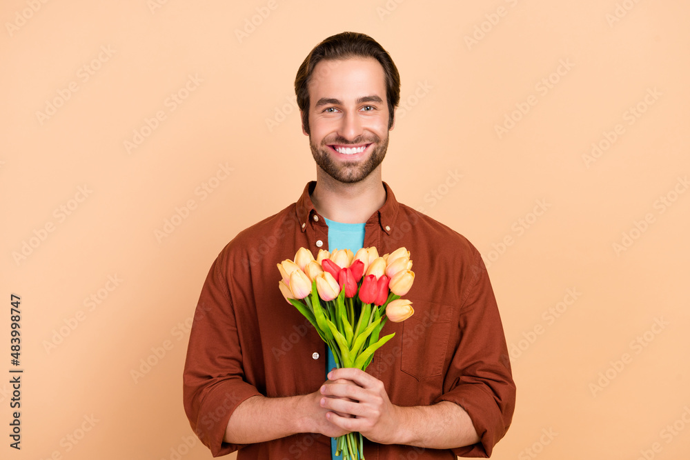 Photo of confident charismatic boyfriend prepare date hold bunch flowers wear casual outfit isolated beige color background Photo of confident charismatic boyfriend prepare date hold bunch flowers wear casual outfit isolated beige color background