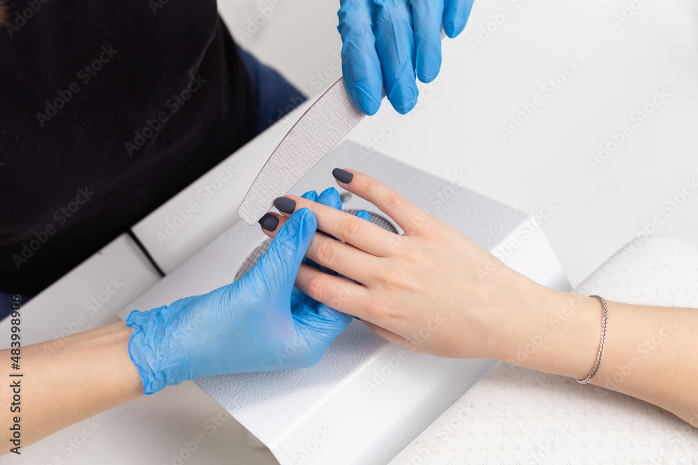 The master in the beauty salon makes the girl a manicure. The master in the beauty salon makes the girl a manicure.