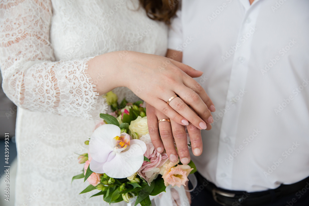 A pair of gold rings for wedding ceremony on bride and groom hands A pair of gold rings for wedding ceremony on bride and groom hands