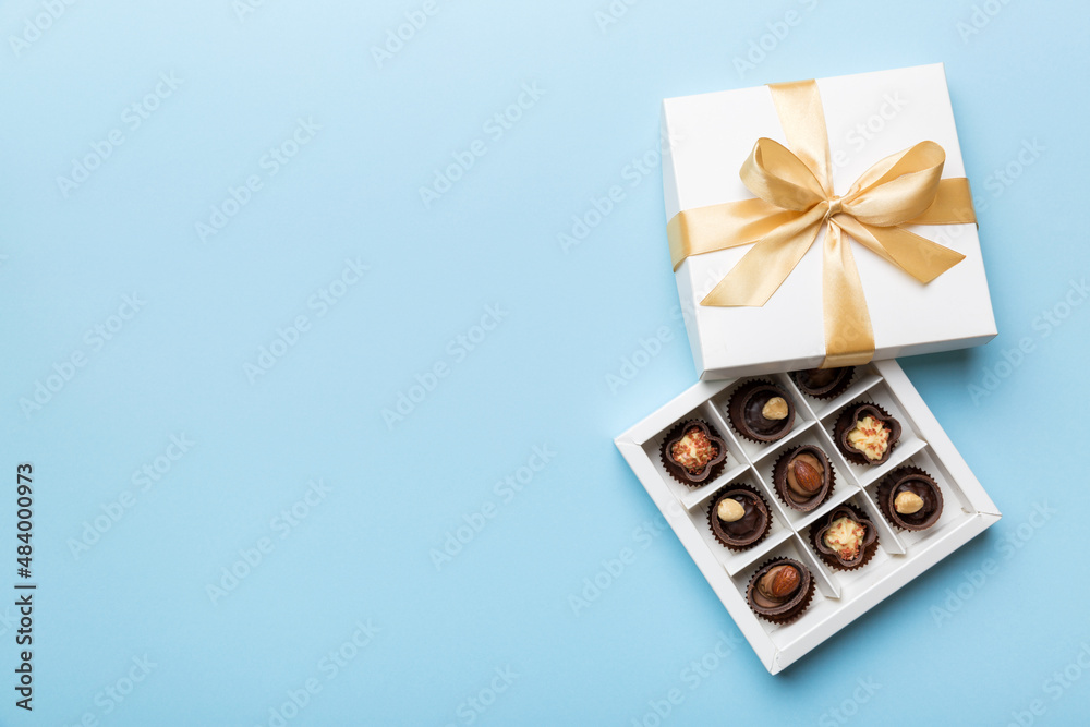 White box with chocolates candies and golden tape. top view with copy space White box with chocolates candies and golden tape. top view with copy space