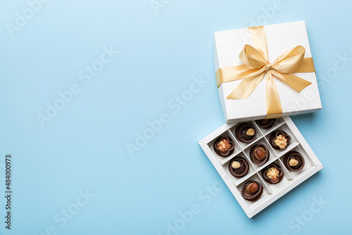 White box with chocolates candies and golden tape. top view with copy space © sosiukin