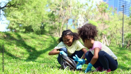 Young girls African American keep trash and cleaning waste around the park. concept of reducing global warming. garbage collection
