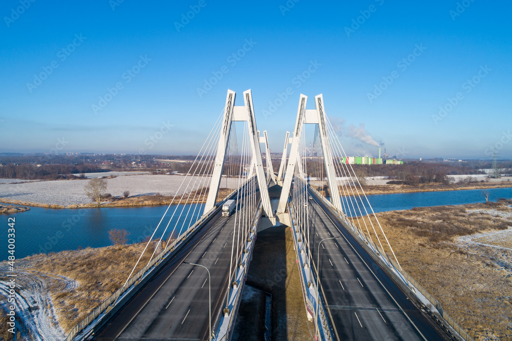 New modern Macharski double cable-stayed three-lane suspension bridge over Vistula River in Krakow, Poland. Aerial view in winter. Part of the ring road around Krakow New modern Macharski double cable-stayed three-lane suspension bridge over Vistula River in Krakow, Poland. Aerial view in winter. Part of the ring road around Krakow