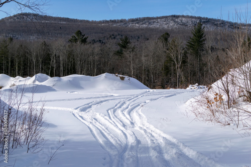 Snowmobile trail in a field with trees