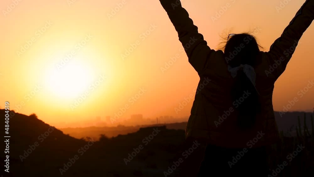 Silhouette of happy Indian woman raising her arms in front of the ...