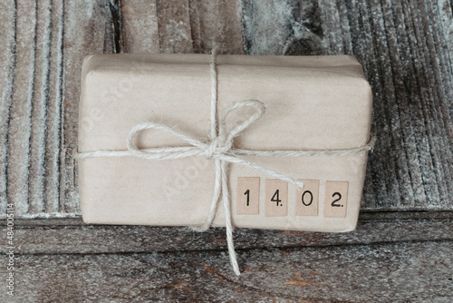 Wooden background with natural colour gift box with ribbon, valentines day. 14.02.