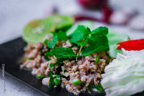 Minced pork larb served with fresh vegetables, a popular Thai food in the Northeast. In Thai, it is smoother than "Larb Moo".
