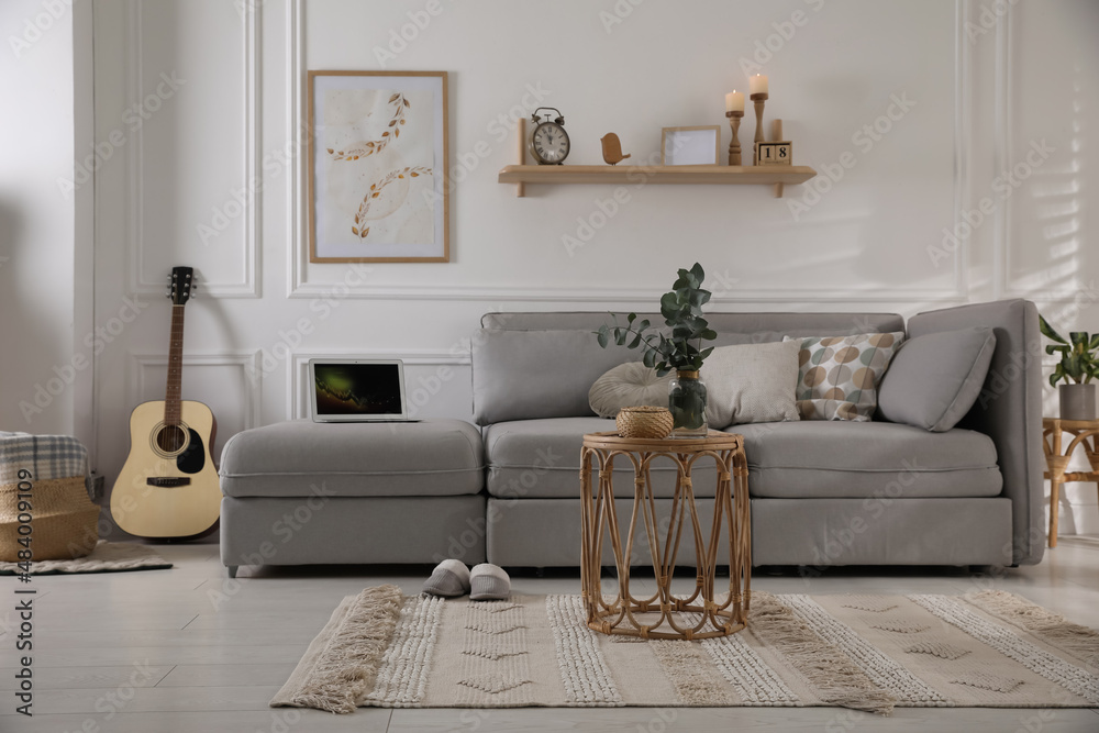 Obraz premium Living room with comfortable grey sofa and stylish interior elements