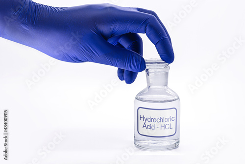 bottle of hydrochloric acid, handling with glove for chemist, chemical solution used in the industry in general, toxic and dangerous product photo