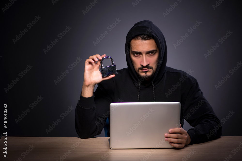 Young male hacker on grey background Young male hacker on grey background
