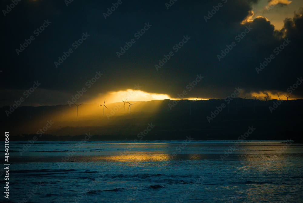 Windmills lit under storm clouds, dramatic light Windmills lit under storm clouds, dramatic light