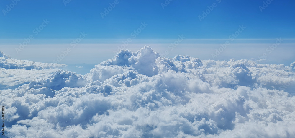 Beautiful sky above the clouds. View of blue sky and clouds from plane window.