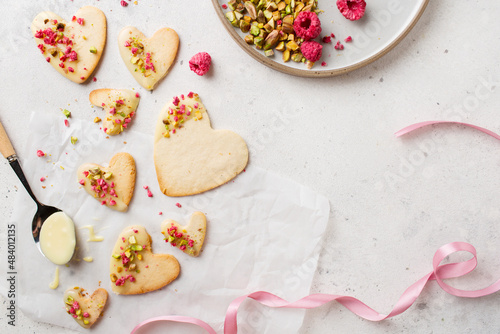Cookie hearts with raspberries. Background for Valentine's Day. Nut cookies. Baking for lovers.