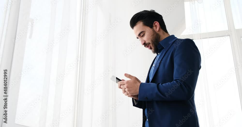 Happy young businessman text messaging using mobile phone Happy young businessman text messaging using mobile phone