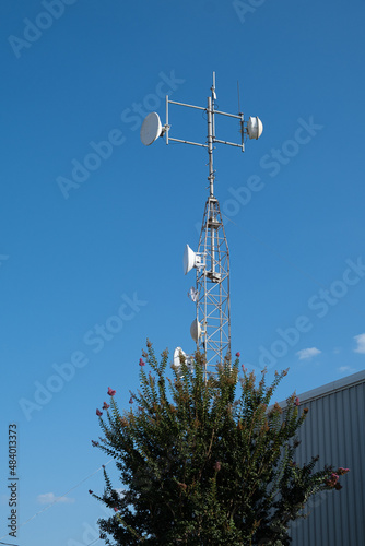 Wireless communications tower with multiple directional antennas and radomes.