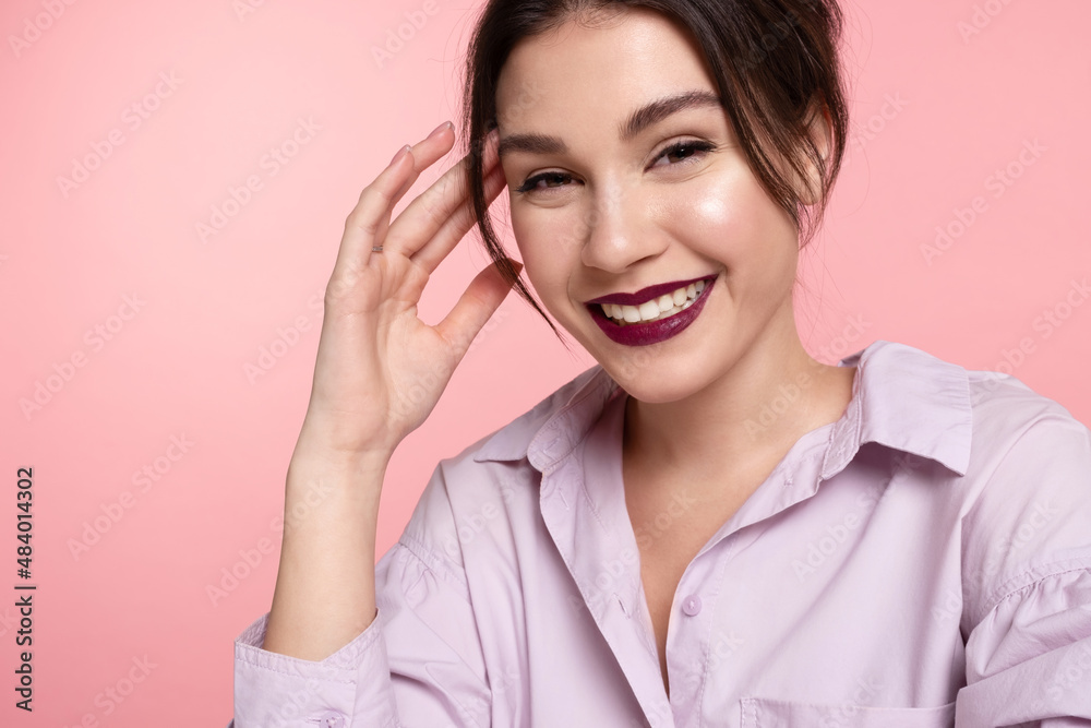 Laughing modern young caucasian girl with perfect trendy make up, glowing healthy skin wearing gentle lilac shirt having fun on pink studio background. Positive emotions, skincare products advertising Laughing modern young caucasian girl with perfect trendy make up, glowing healthy skin wearing gentle lilac shirt having fun on pink studio background. Positive emotions, skincare products advertising