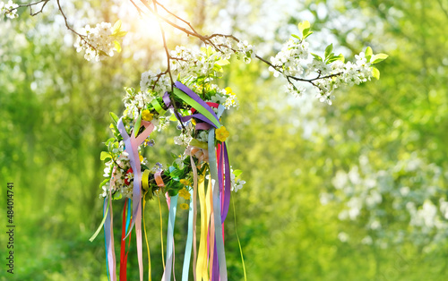 Tableau sur toile Spring flower wreath with colorful ribbons in garden, green natural background