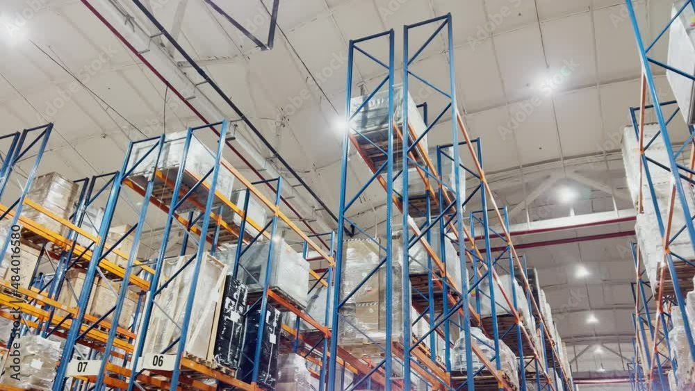 Bottom view footage of high shelving warehouse goods of logistics company, lots of light, large hangar, multi level storage