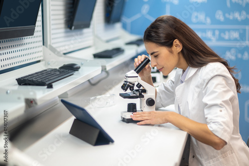 Woman sideways to camera looking through microscope