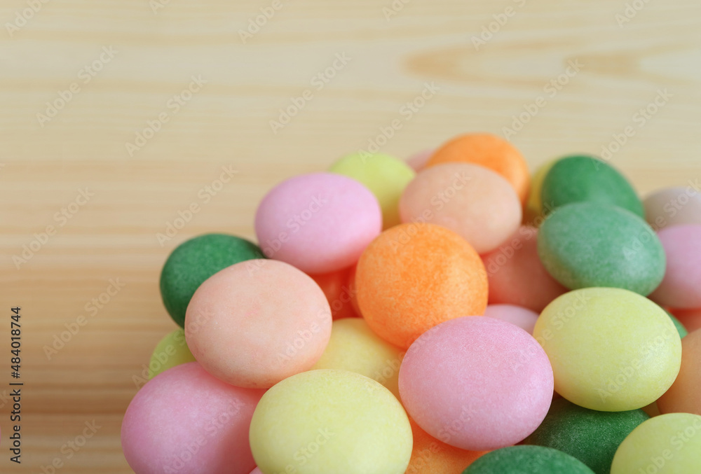 Pile of Beautiful Pastel Colored Sugar Coated Candies on Wooden Backdrop Pile of Beautiful Pastel Colored Sugar Coated Candies on Wooden Backdrop
