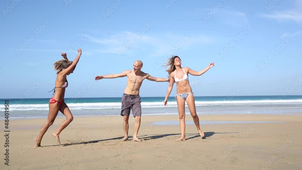 Multiracial group of friends jumping on the beach and celebrating success at seaside Multiracial group of friends jumping on the beach and celebrating success at seaside