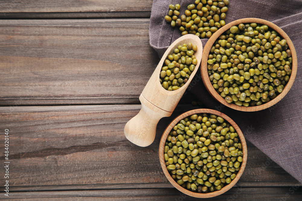 Soy beans with bowls and scoop on wooden background Soy beans with bowls and scoop on wooden background