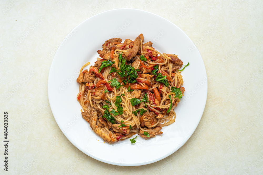 Top view of a plate with rice noodles, pork meat, peppers, carrots, onions. Top view of a plate with rice noodles, pork meat, peppers, carrots, onions.
