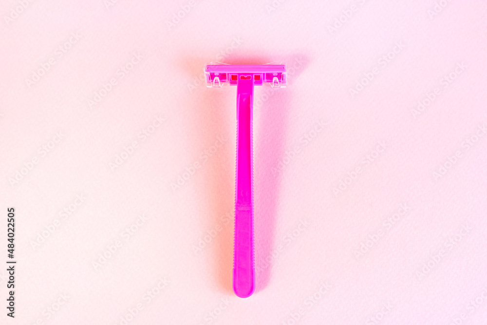 Pink disposable woman razor on light pastel background. Hair removing, epilation procedure and shaving concept. Pink disposable woman razor on light pastel background. Hair removing, epilation procedure and shaving concept.