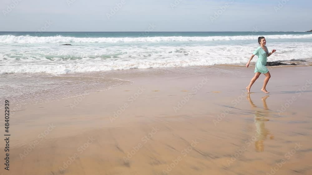 Beautiful woman alone at seaside walking and splashing water in Fuerteventura Beautiful woman alone at seaside walking and splashing water in Fuerteventura