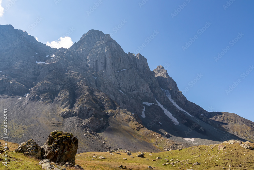 A panoramic view on the sharp mountain peaks of the Chaukhi massif in the Greater Caucasus Mountain Range in Georgia, Kazbegi Region. Mountain Ridges, Hiking. Georgian Dolomites.