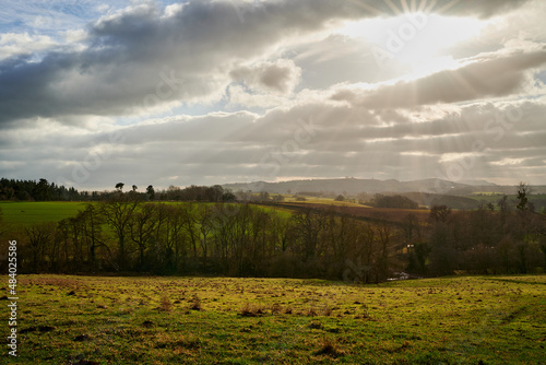 winter sunbeams over english countryside and rolling hills in manner of revelation or religion