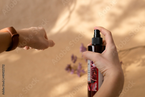 Applying body spray to the skin