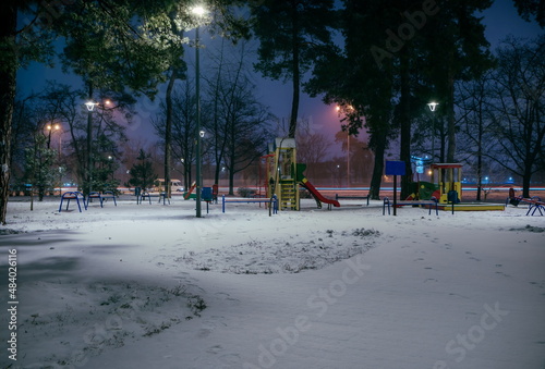 The playground in the night park with lanterns in the winter. Be