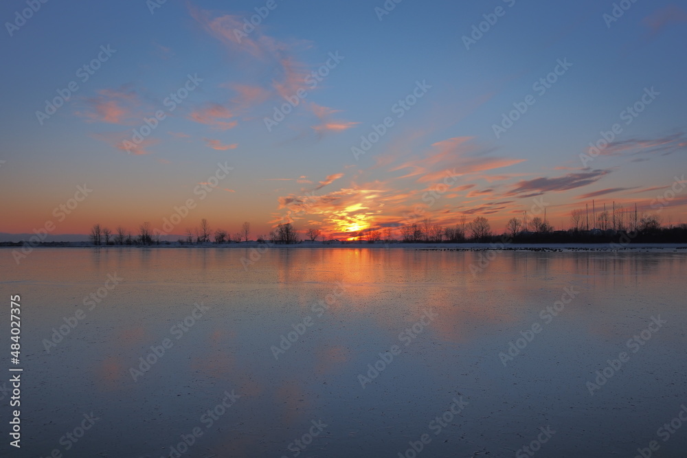 Winter sunset reflecting off frozen water 