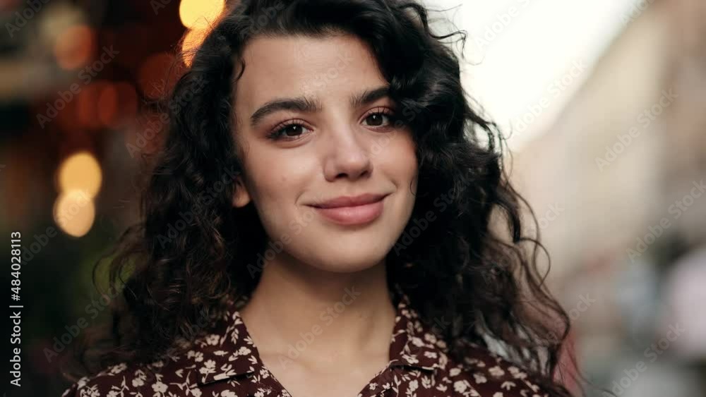 Close-up portrait of smiling girl looking at. Curly hair fashion model face smiling. Portrait of joyful girl open eyes. Female nature beauty Close-up portrait of smiling girl looking at. Curly hair fashion model face smiling. Portrait of joyful girl open eyes. Female nature beauty