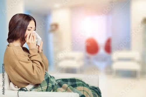 Woman freezes at home. Sick girl wrapped in comfortable blanket to keep warm. Winter cold and flu concept