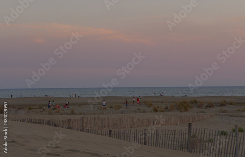 sunset on the beach with wooden fences and dunes