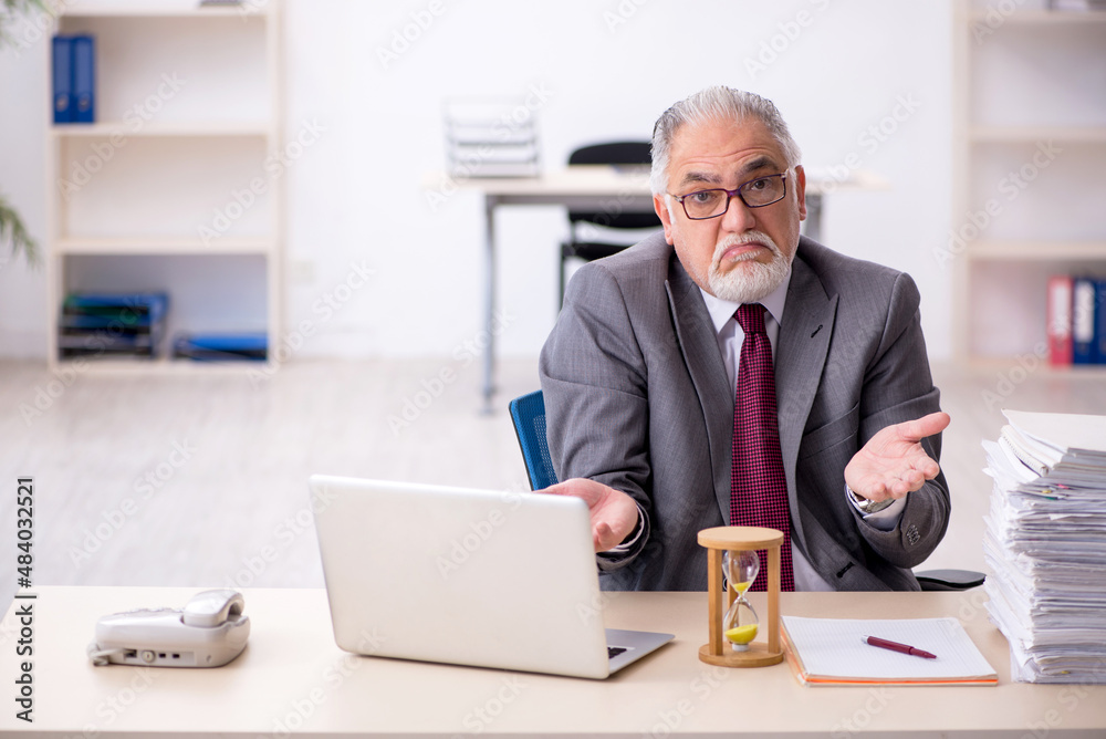 Old male employee in time management concept Old male employee in time management concept