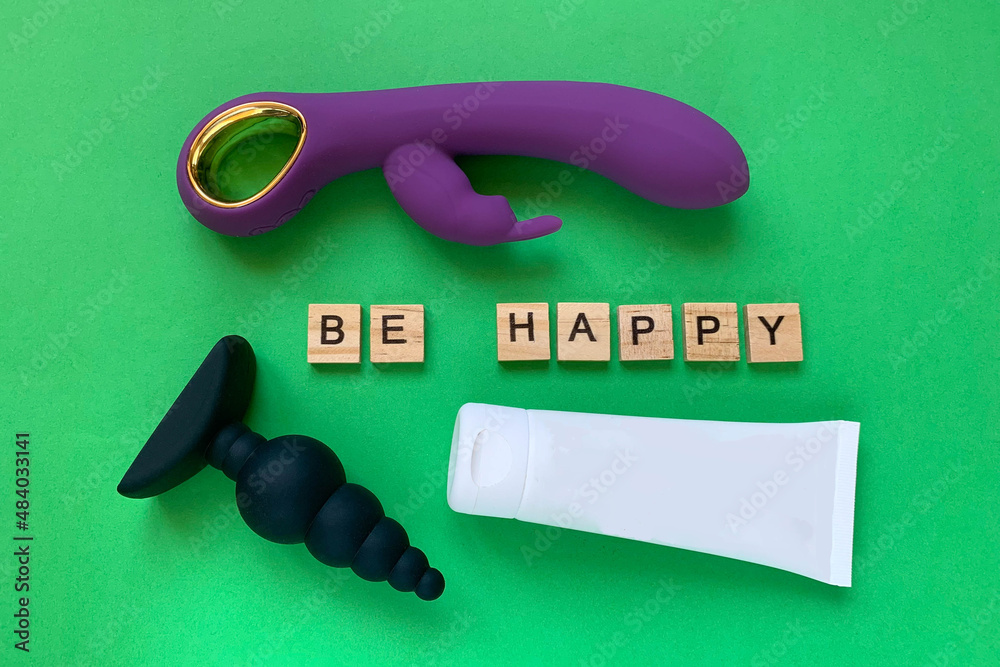 Sex toys and lubricant. Vibrator, butt plug and tube on green background.  Letter BE HAPPY. Useful for sex shop Stock Photo | Adobe Stock