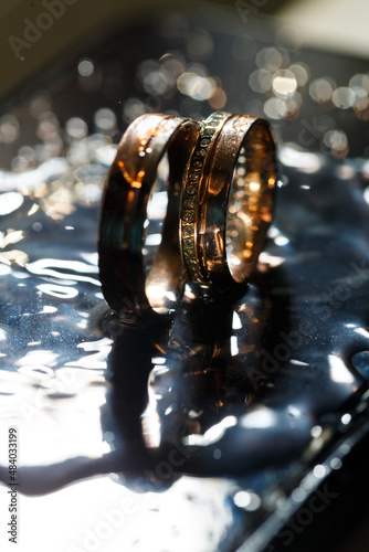 Wedding rings with water droplets,The engagement ring set.,Beautiful silver background with wedding rings and stars