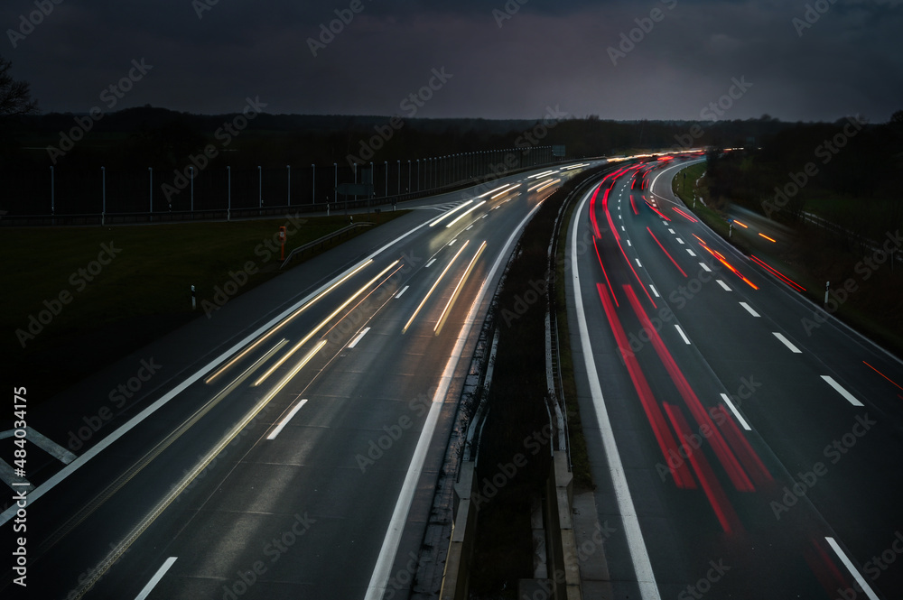 Lights of driving cars on a highway at night in Germany, long exposure with motion blur, copy space