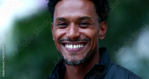Portrait of mixed race man smiling to camera. Friendly happy african american descent person face outdoors