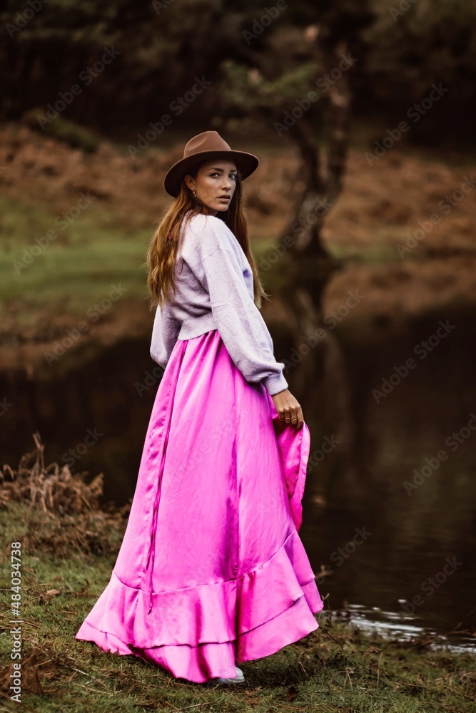 Obraz premium woman in a hat and a pink dress in madeira portugal