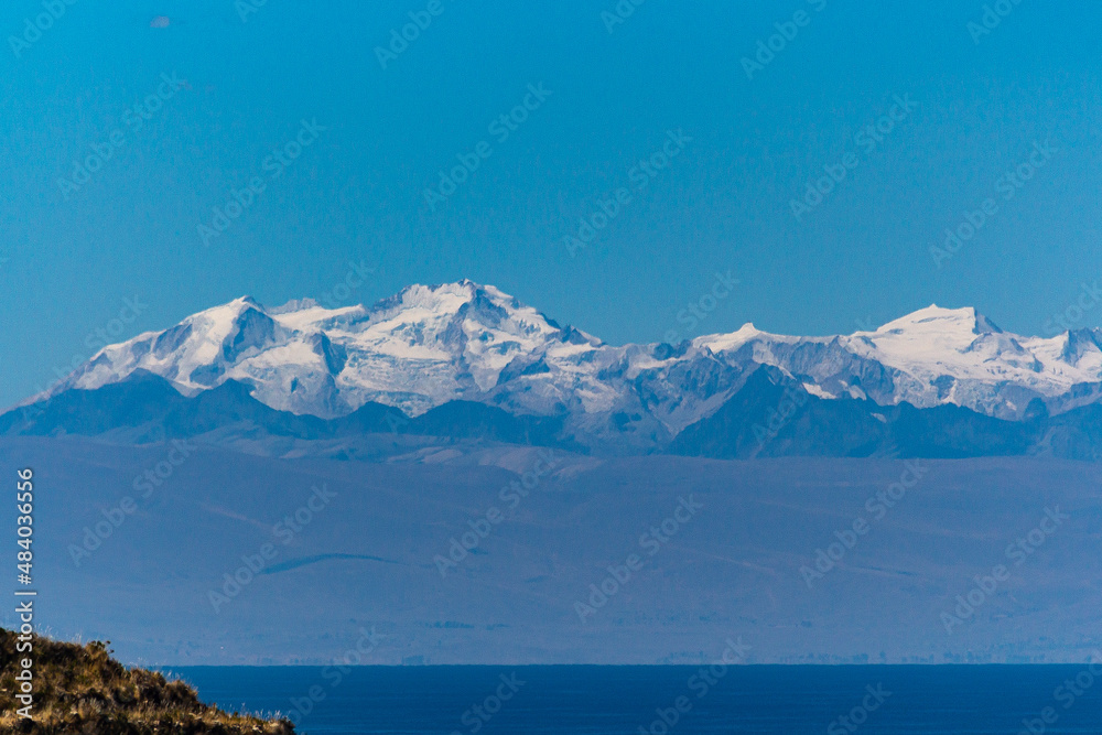 The snowed Andes mountains with lake on bottom
