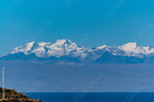 The snowed Andes mountains with lake on bottom